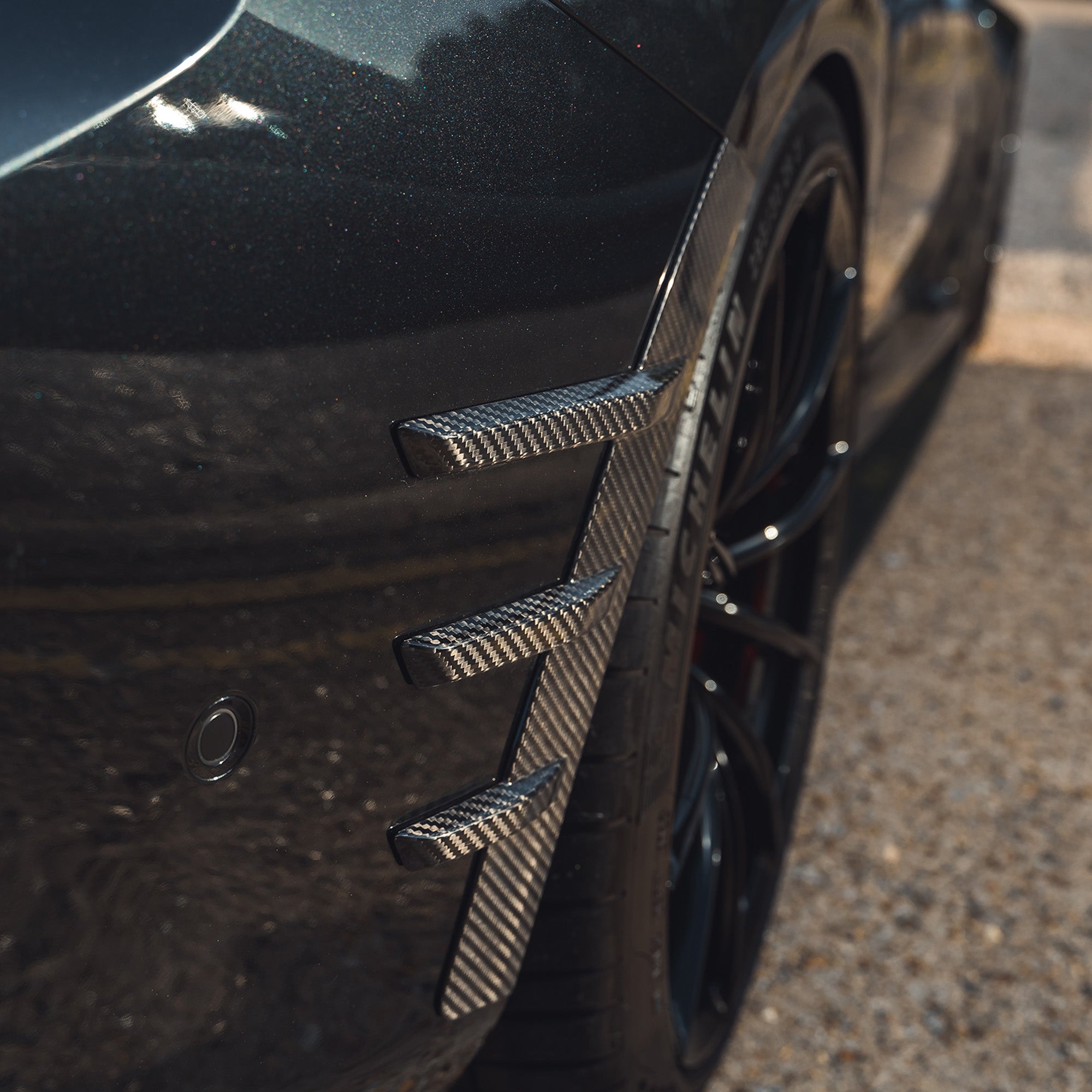 BMW G87 M2 carbon fiber rear side fender trim accessory by CT Carbon, featuring a sleek, lightweight design for sporty style.