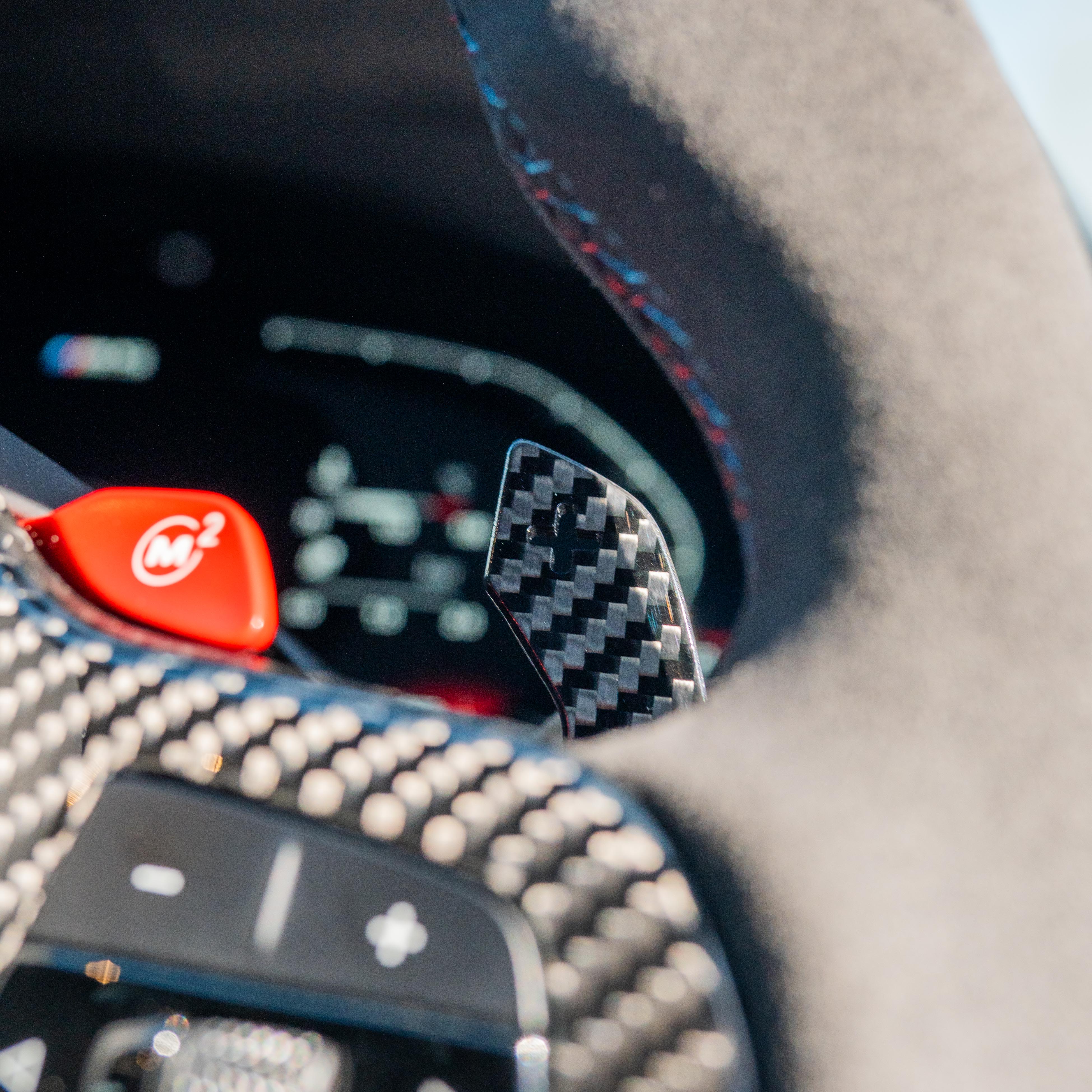 BMW Gxx carbon fibre magnetic shifter paddles by CT Carbon, close-up view showing sleek black design and textured surface.