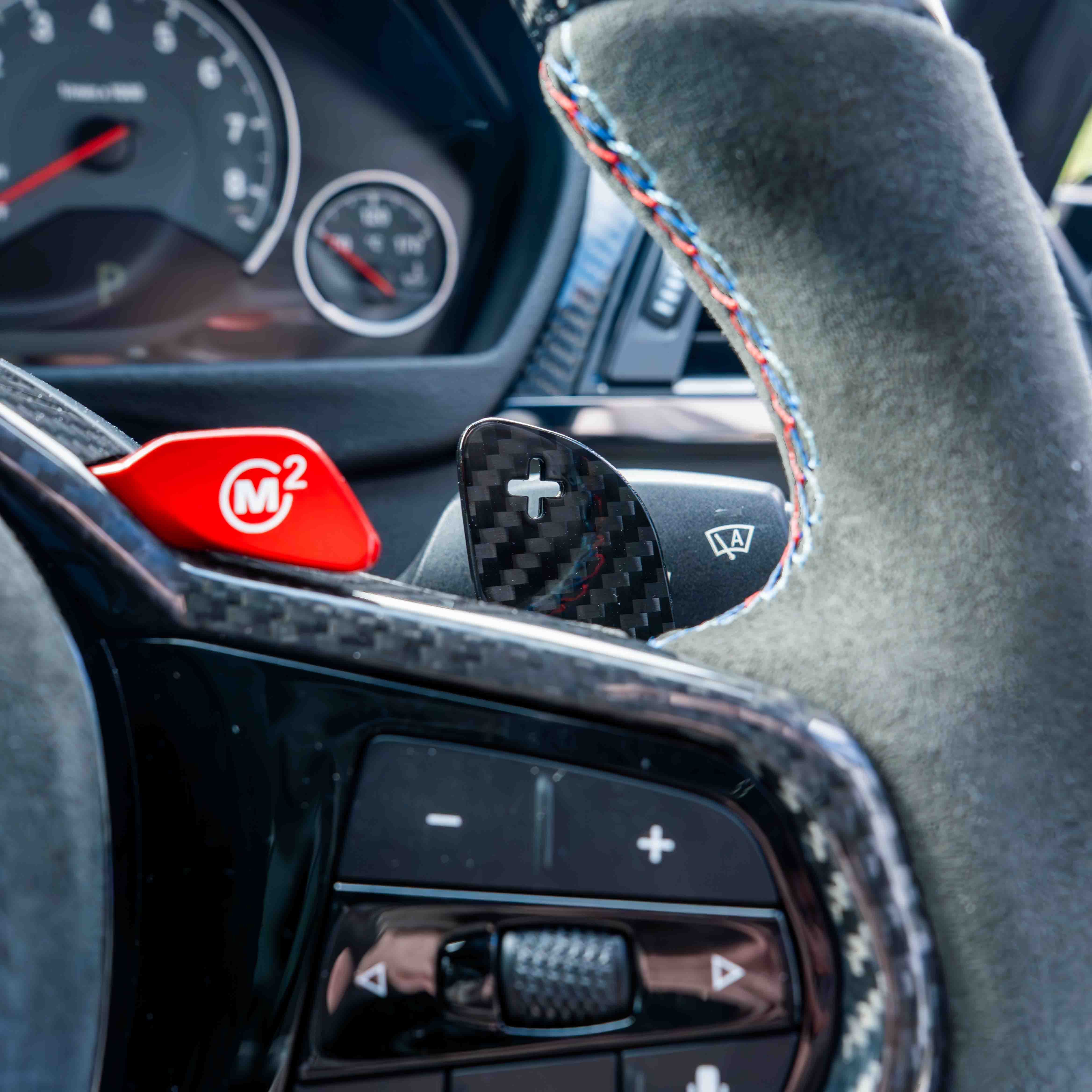 BMW Gxx carbon fiber magnetic shifter paddles by CT Carbon, close-up view showing sleek black design and paddle details.