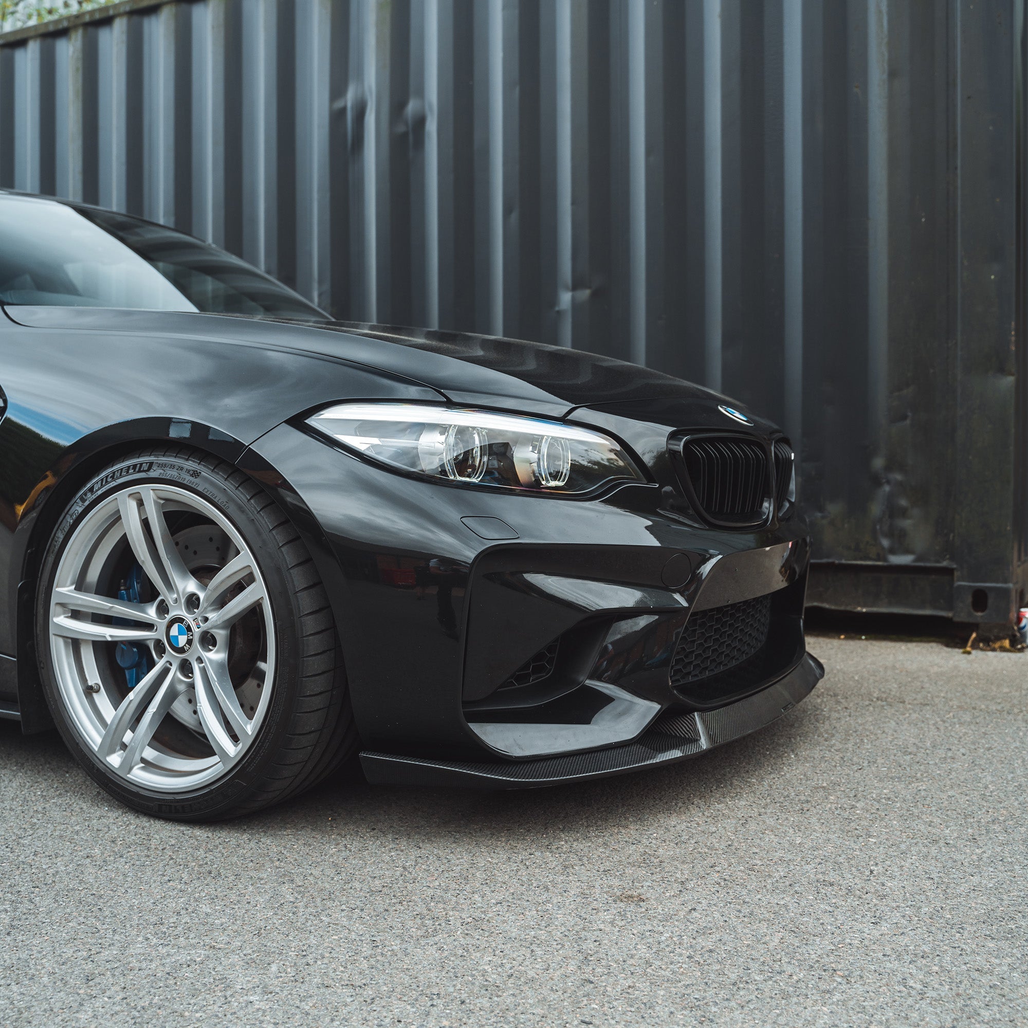 BMW M2 F87 N55 carbon fibre splitter V2 by CT Carbon, showing the sleek, textured carbon fiber design mounted on the front of the car.