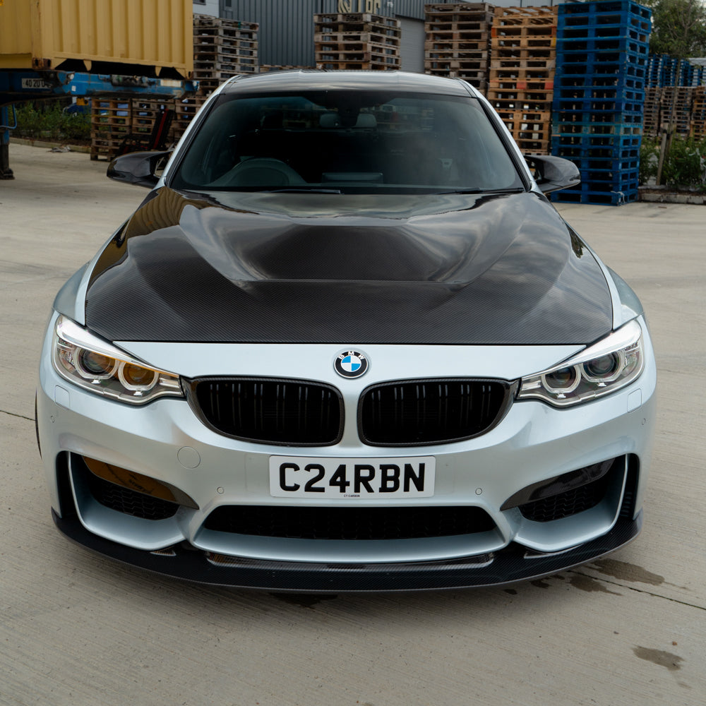 BMW M3 M4 F80 F82 F83 carbon fiber canards, high-performance front accessories by CT Carbon, shown mounted on the vehicle.