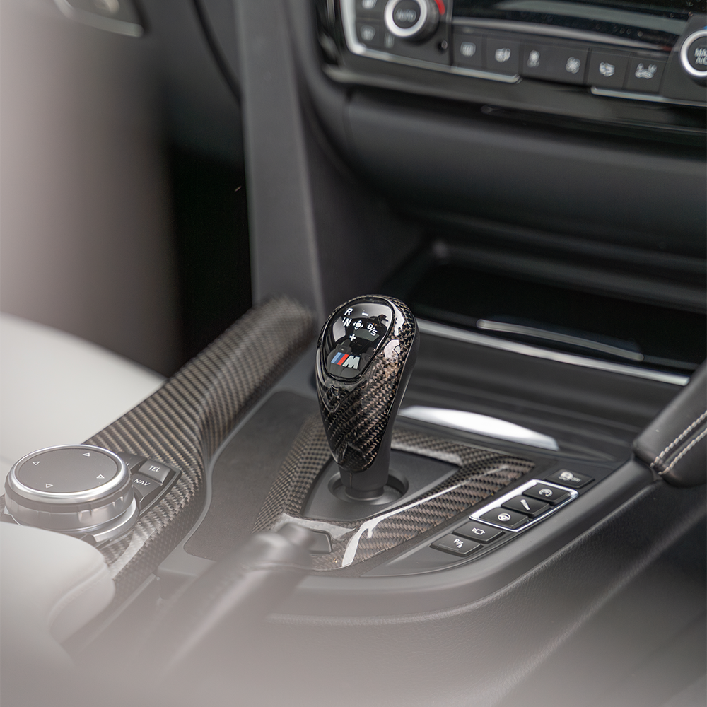 BMW M3 M4 F80 F82 F83 F87 ALCANTARA and carbon fiber shifter surround for right-hand drive by CT Carbon, close-up view.