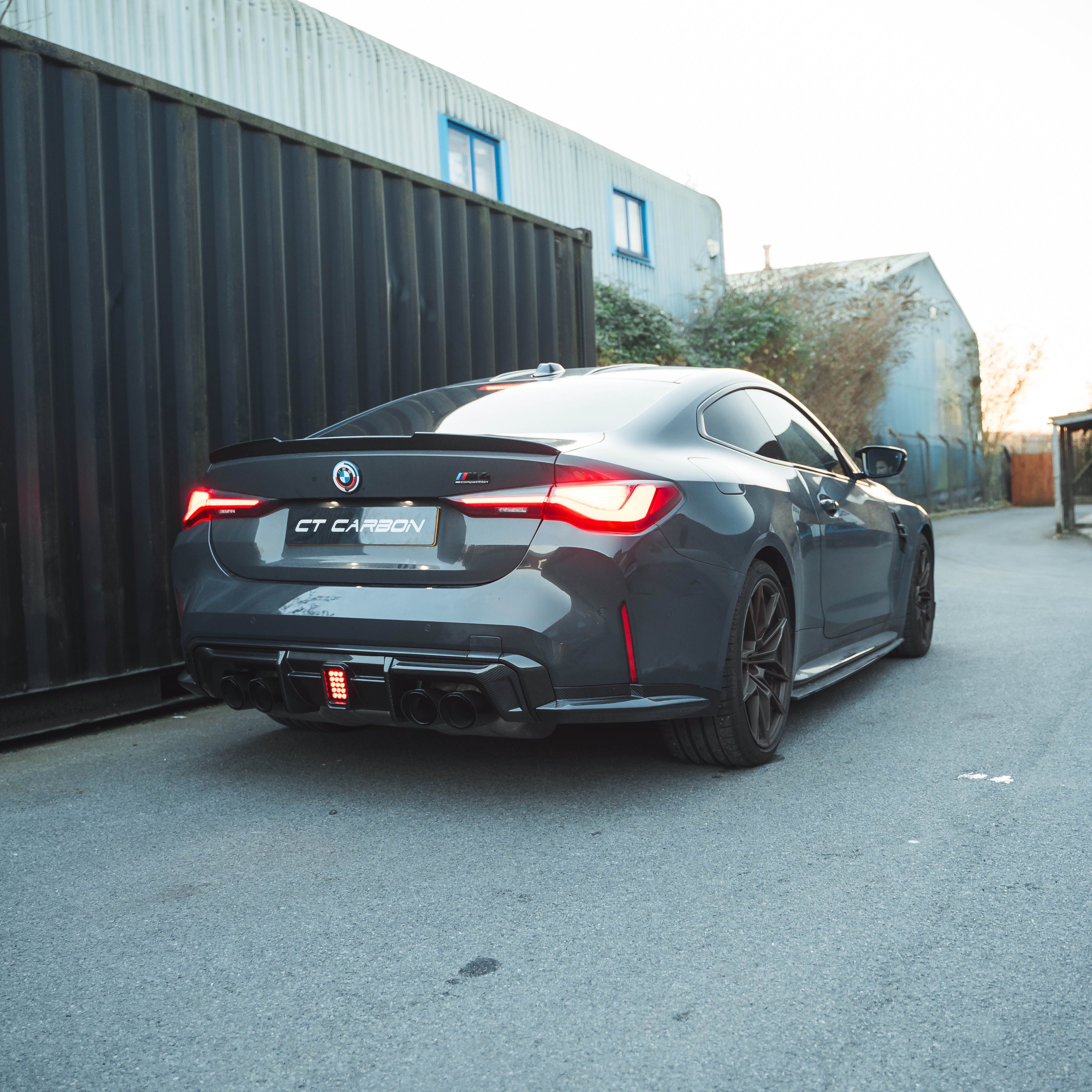 BMW M3/M4 G80 G82 carbon fibre diffuser with LED lights, designed by CT Carbon, showcasing sleek, aerodynamic styling.