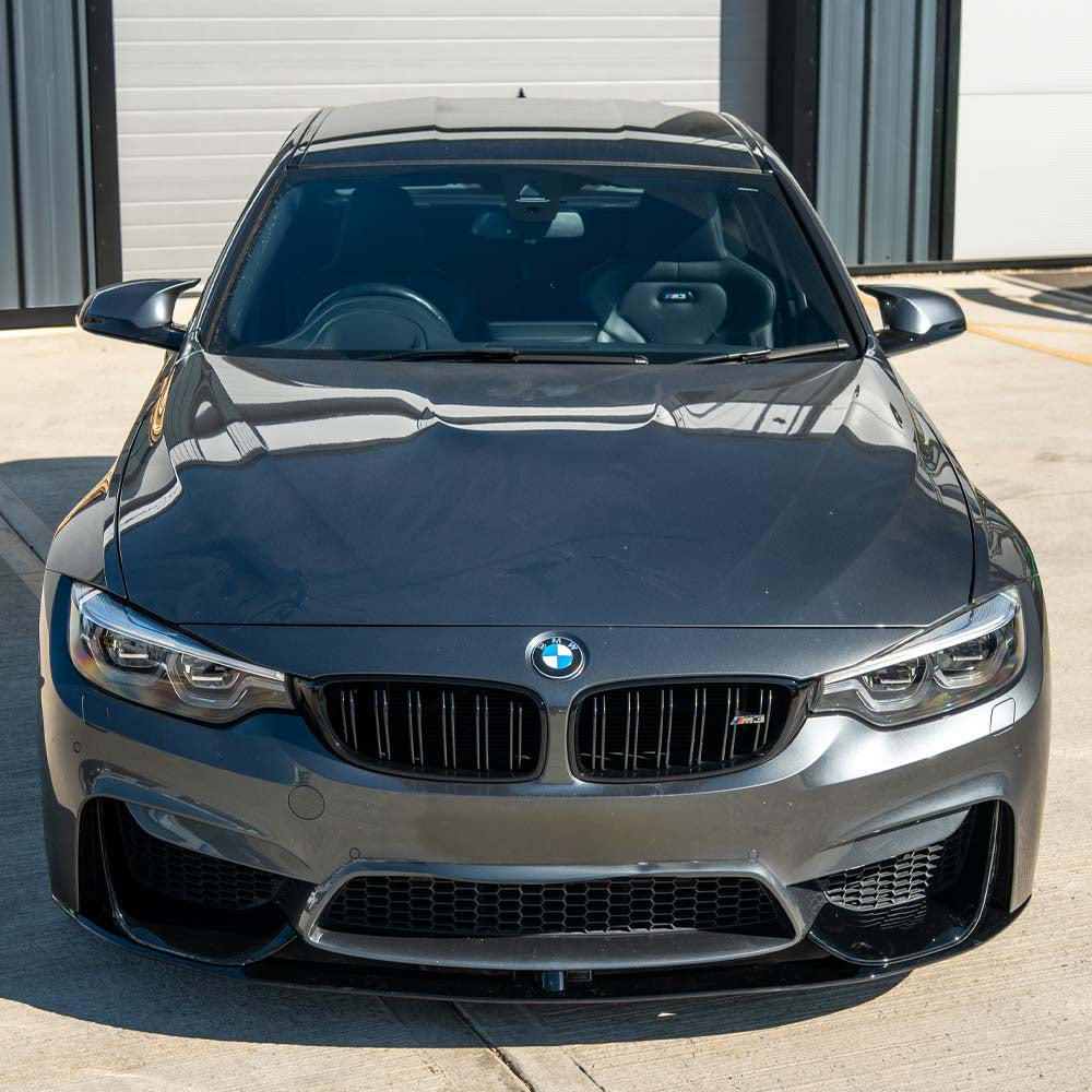 BMW M4 F82 coupe with CT Carbon full gloss black kit installed, showing sleek exterior enhancements and aerodynamic details.