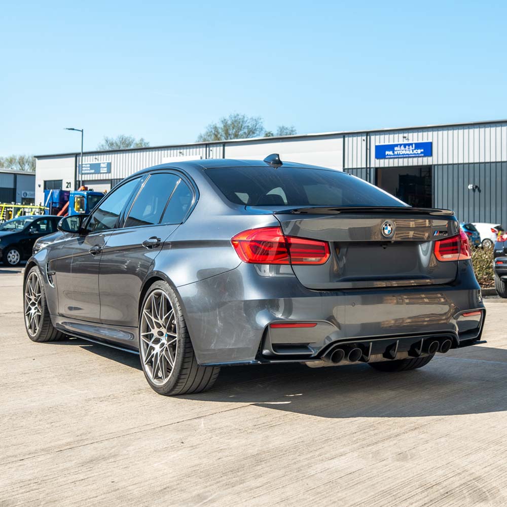 BMW M3 (F80) 2014-2020 full gloss black kit by CT Carbon, showing close-up of sleek, shiny car body parts and finish.