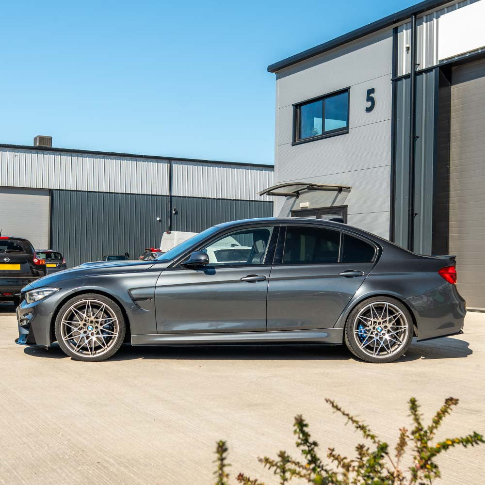 BMW M3 M4 F80 F82 F83 CT Carbon gloss black side skirts installed on coupe, showcasing sleek, aerodynamic automotive body enhancements.