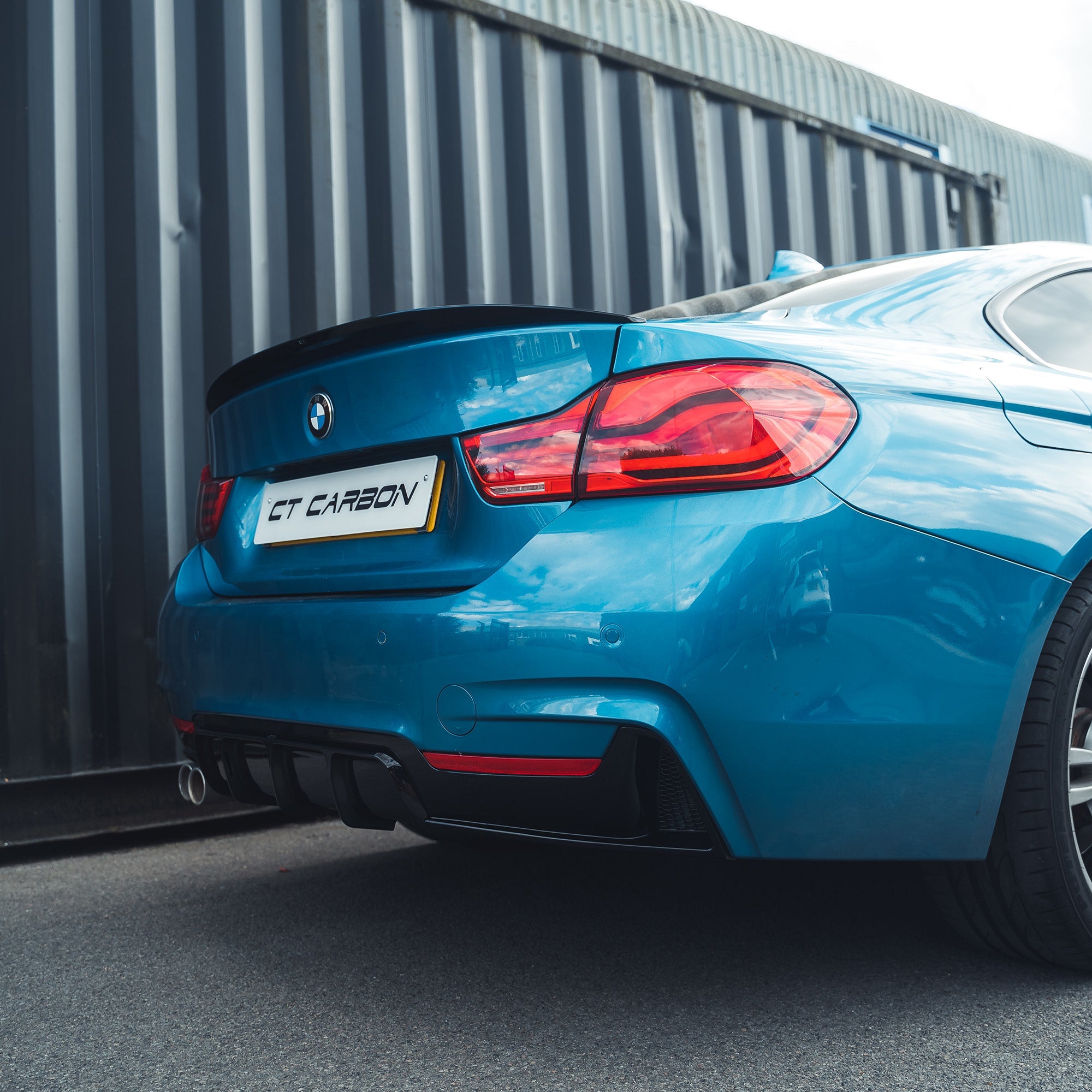 BMW 4 Series F32 2013-2020 gloss black full kit with twin exhaust by CT Carbon, featuring blue accents and sporty design.