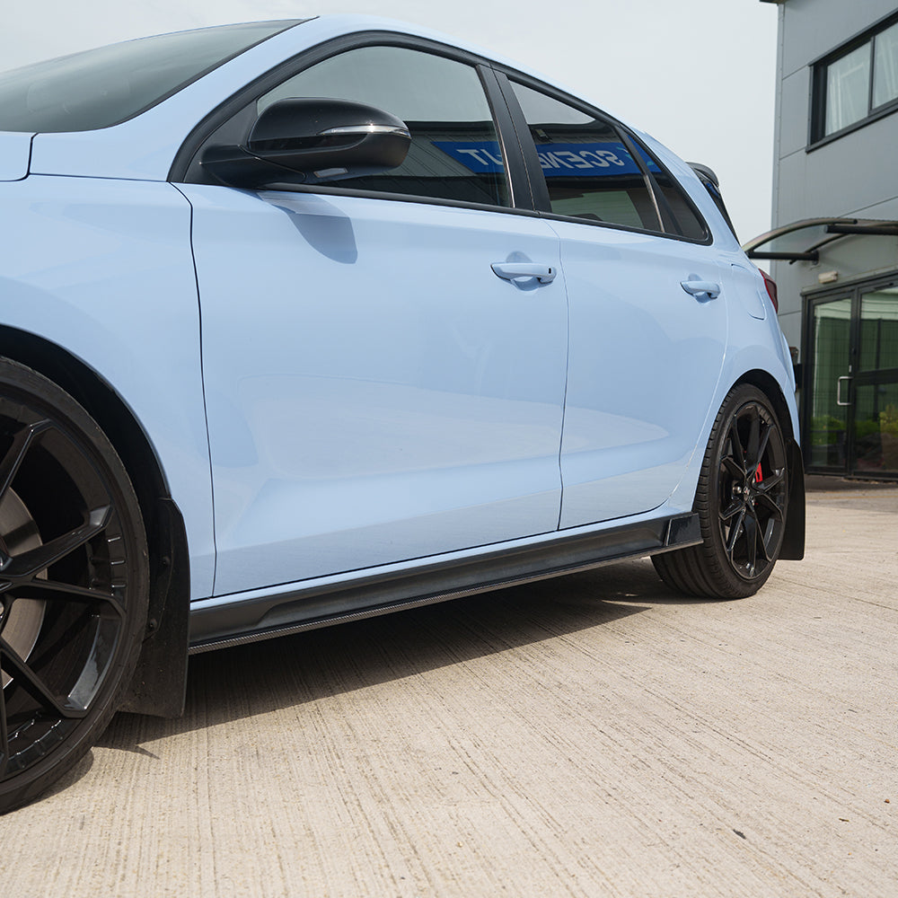 Hyundai i30N carbon fibre side skirts by CT Carbon, sleek aerodynamic car accessories, shown on a white background.