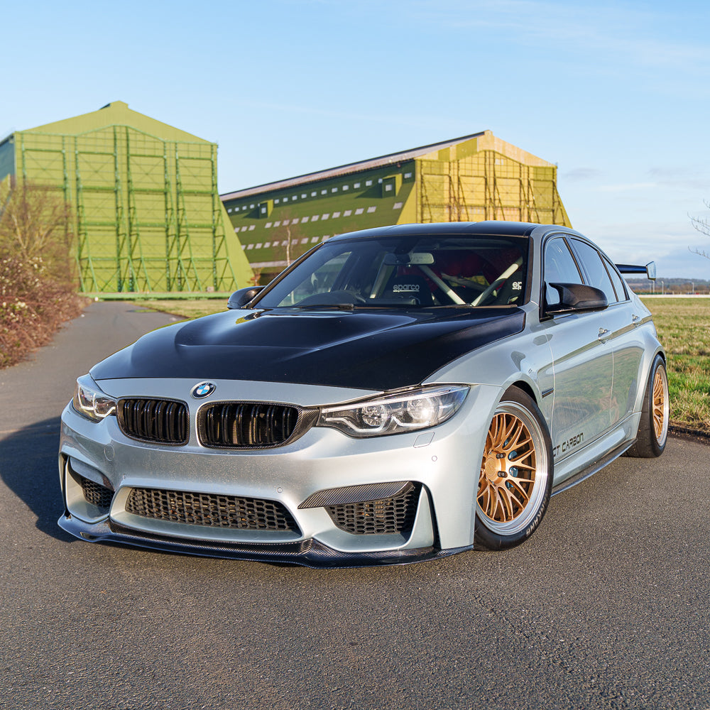 BMW M3 M4 F80 F82 F83 carbon fibre splitter by CT Carbon, showing detailed view of the V4 splitter on a sports car.