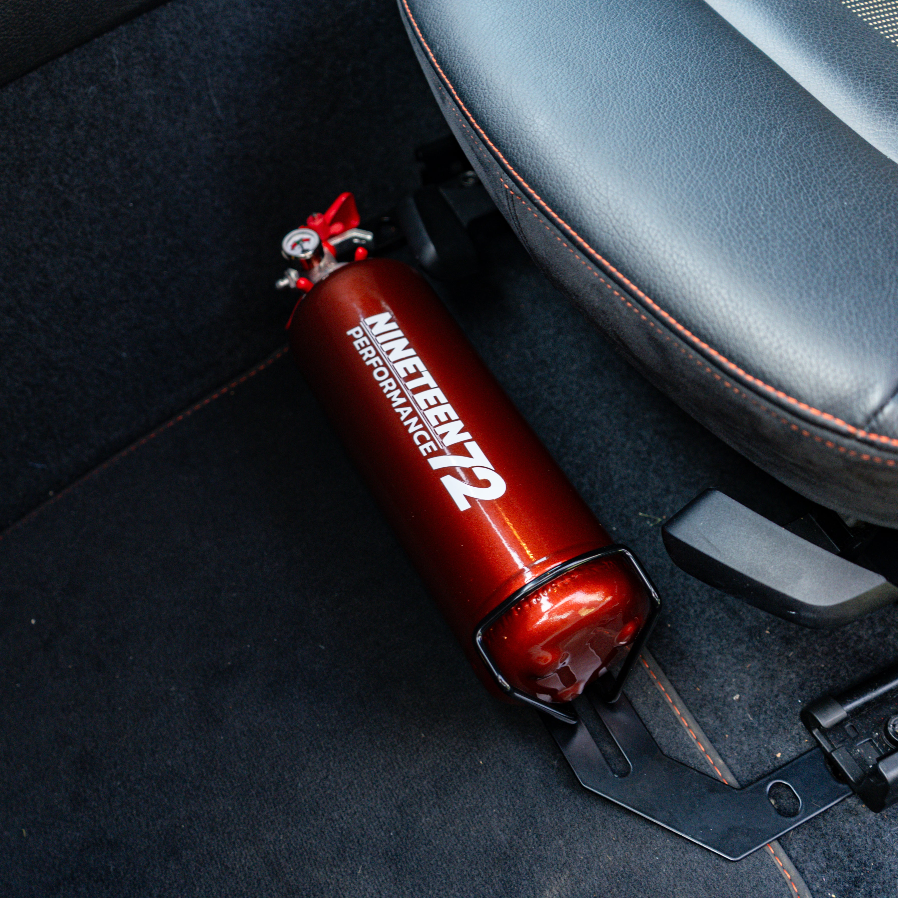 Race Safe BMW F8X footwell fire extinguisher kit with compact fire extinguishers in vehicle footwell area.