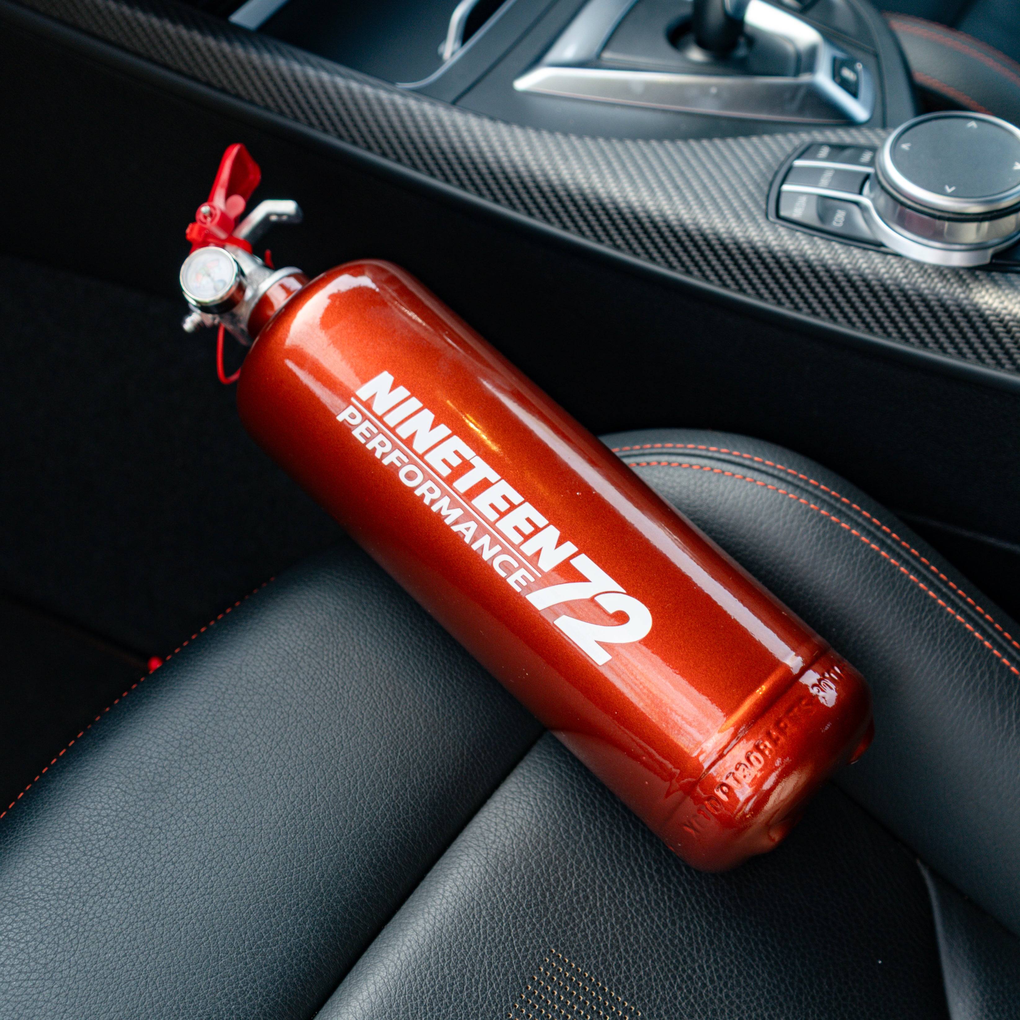 BMW F8X fire extinguisher kit by Race Safe showing compact fire extinguishers in a vehicle footwell.