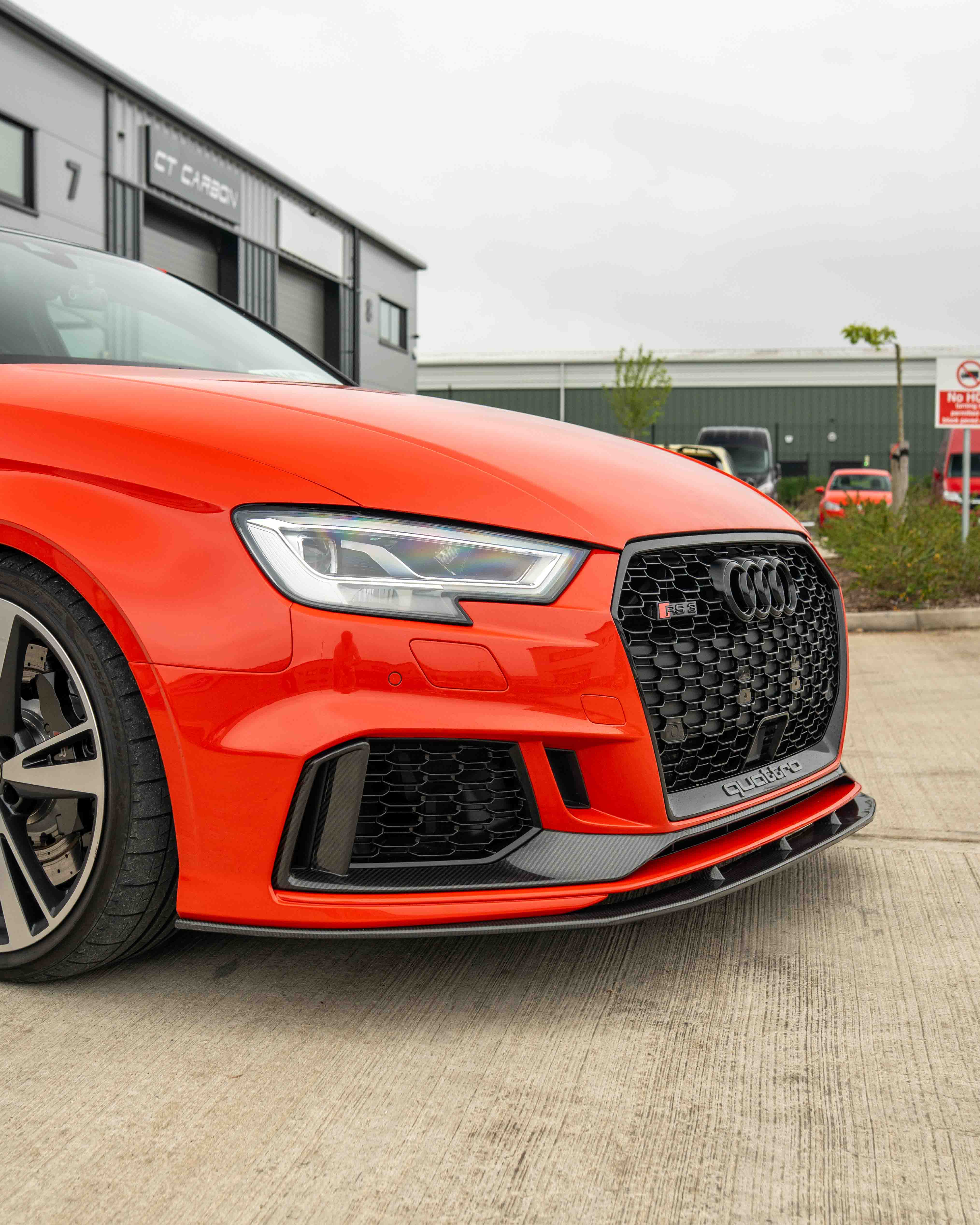 Carbon fiber splitter for Audi RS3 8V saloon, V1 design by CT Carbon, enhances aerodynamics and sporty appearance.