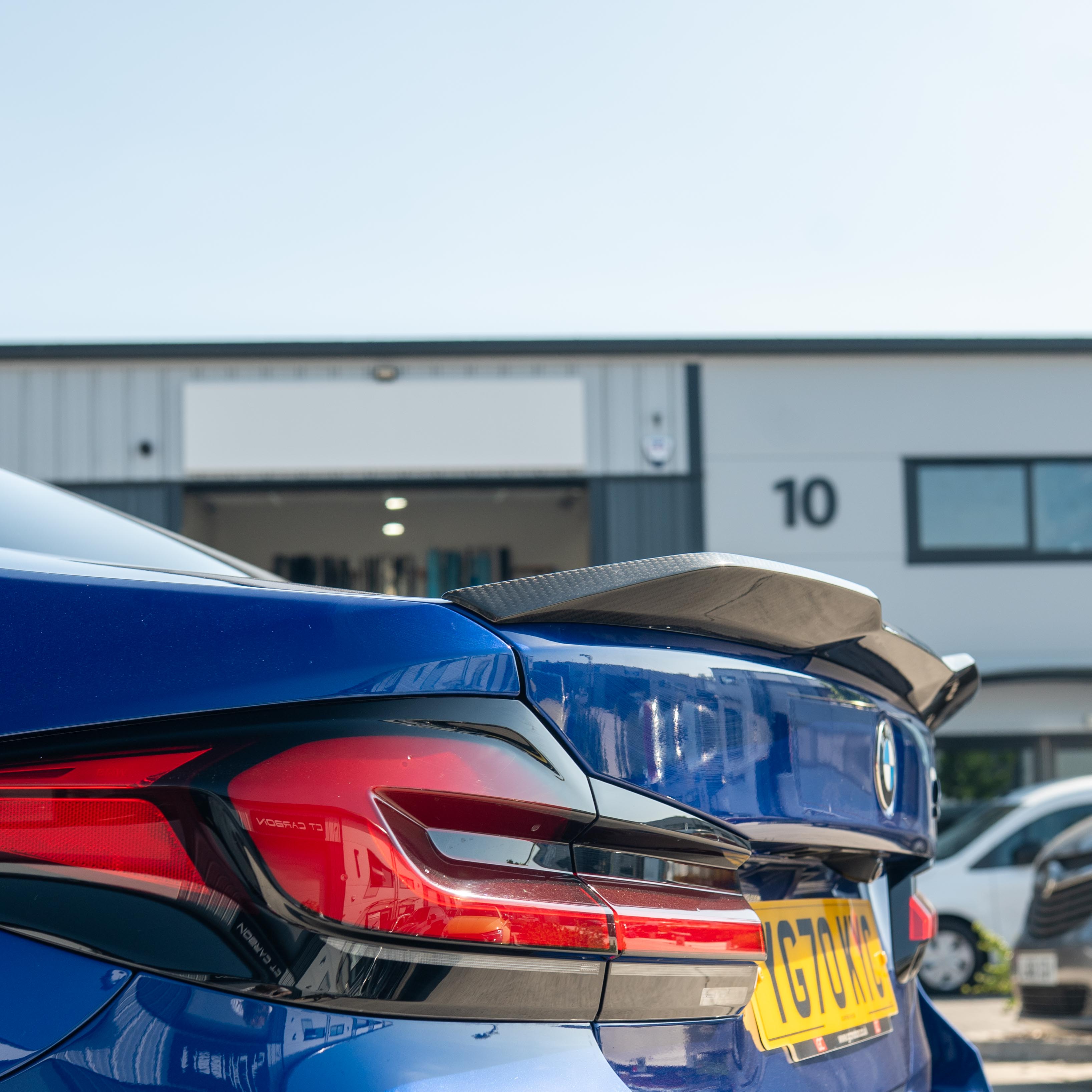 BMW M5 F90 and G30 5 Series carbon fibre spoiler by CT Carbon, shown on a sleek black car with close-up angle.