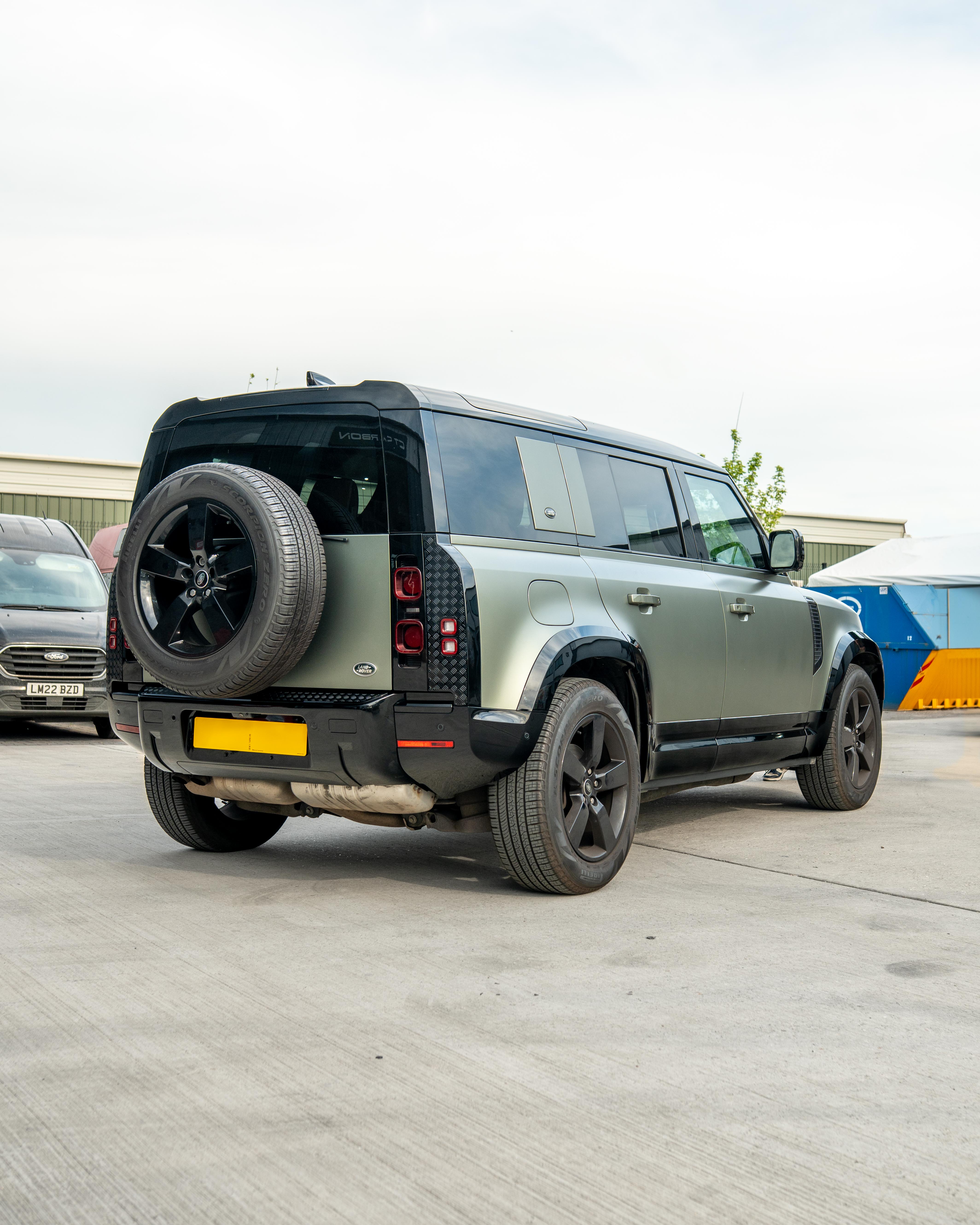 Gloss black door panels for Land Rover Defender L663 110 by CT Carbon, shown on a vehicle with close-up detail.
