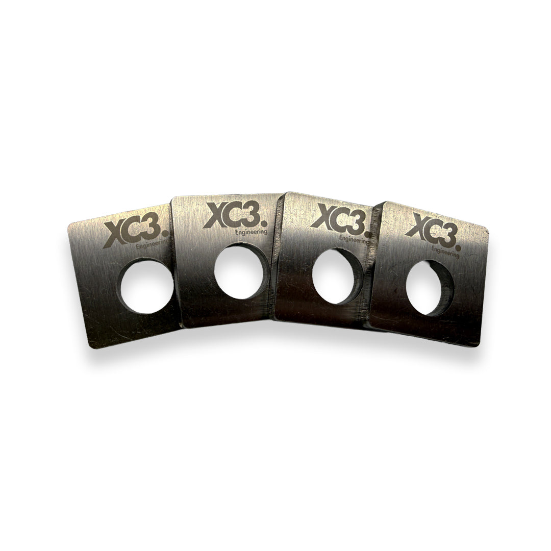 BMW M3 E92 suspension camber lockout shims by XC3 Engineering, close-up of black metal shims for alignment adjustment.