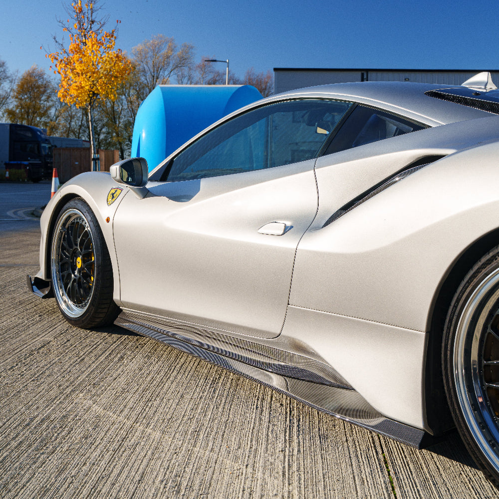 Ferrari 488 Pista carbon fibre side skirts by CT Carbon, close-up view showing sleek design and textured material.