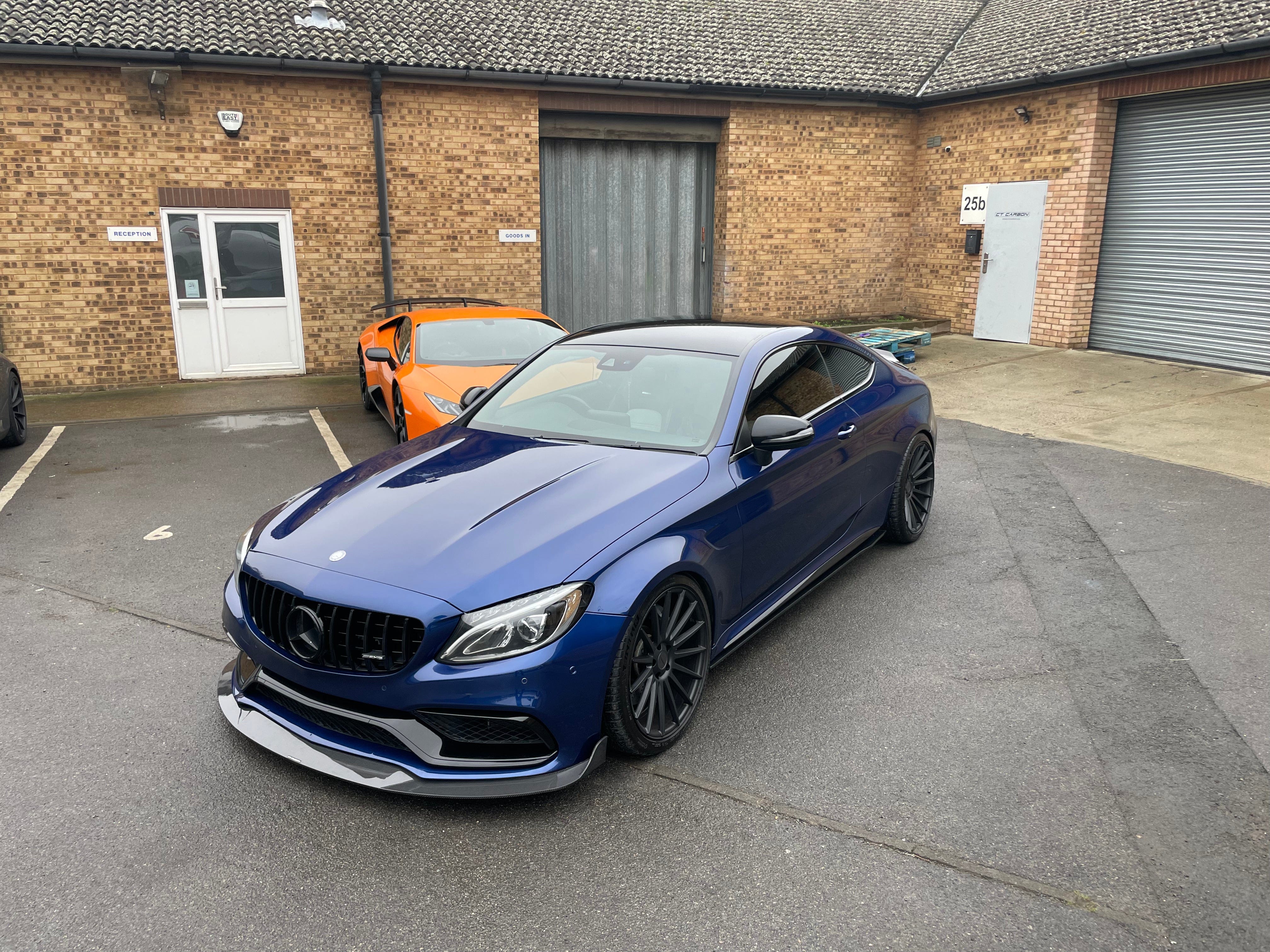 Mercedes W205 C63 coupe convertible carbon fiber splitter by CT Carbon, showcasing the aerodynamic design and textured finish.