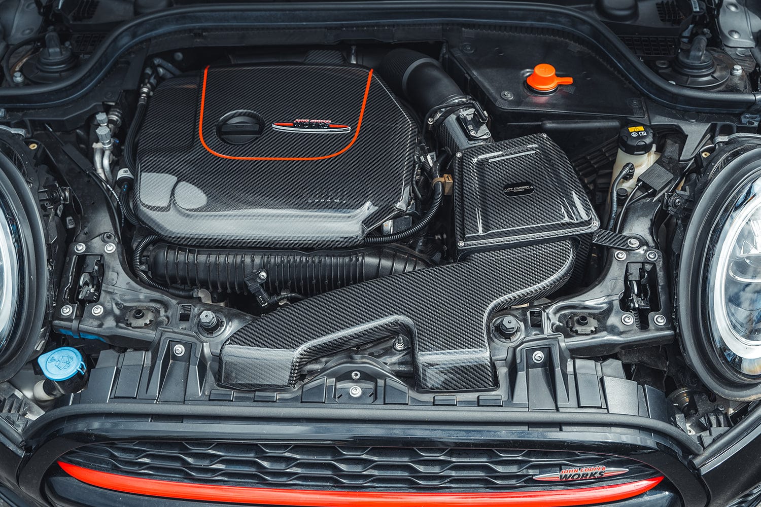 Mini Cooper S JCW F56 carbon fiber engine cover by CT Carbon, showcasing a sleek, lightweight automotive accessory with textured finish.