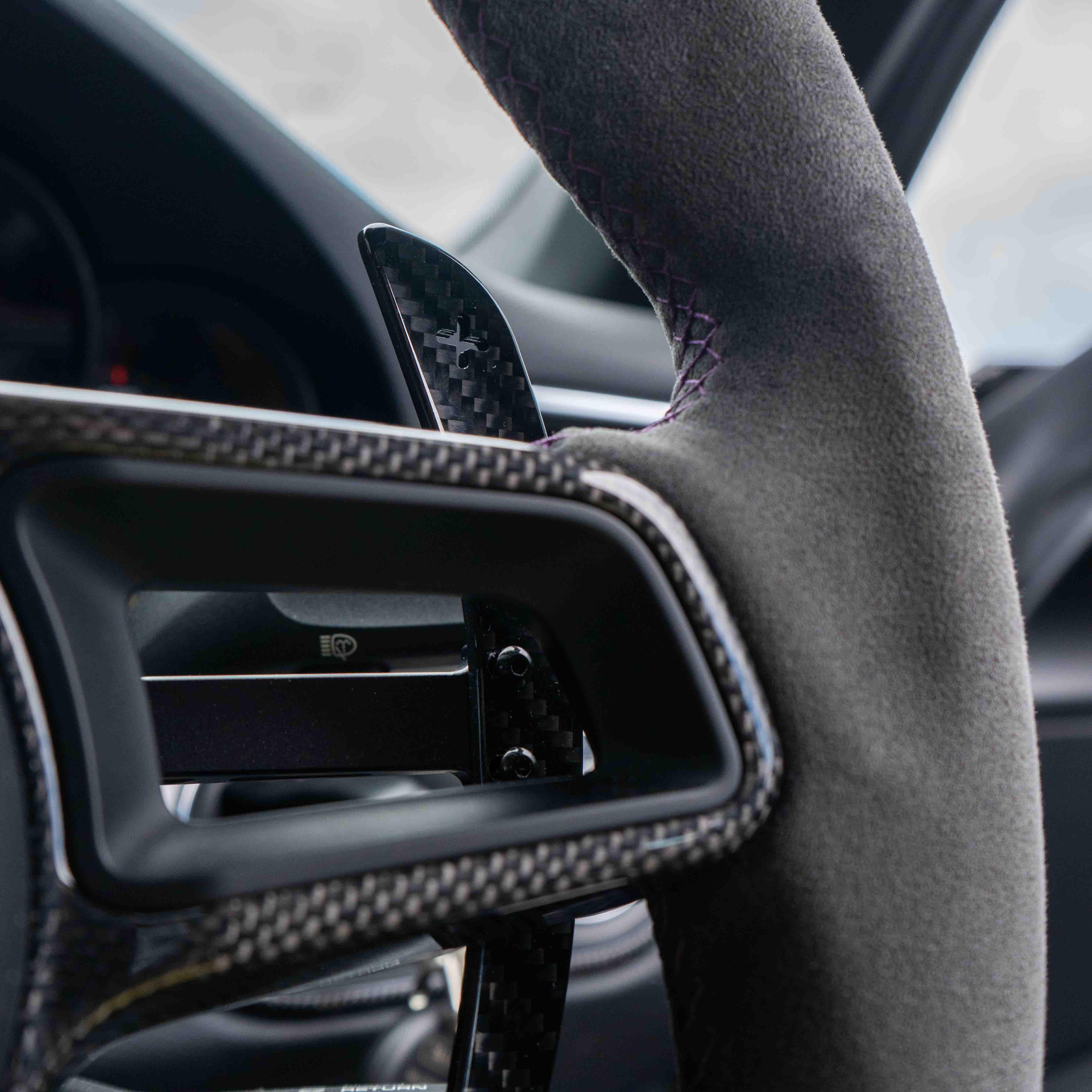 Carbon fiber paddle shifters for Porsche 911, Cayman, Boxster, Cayenne, and Macan 2013+ by CT Carbon, shown in close-up.