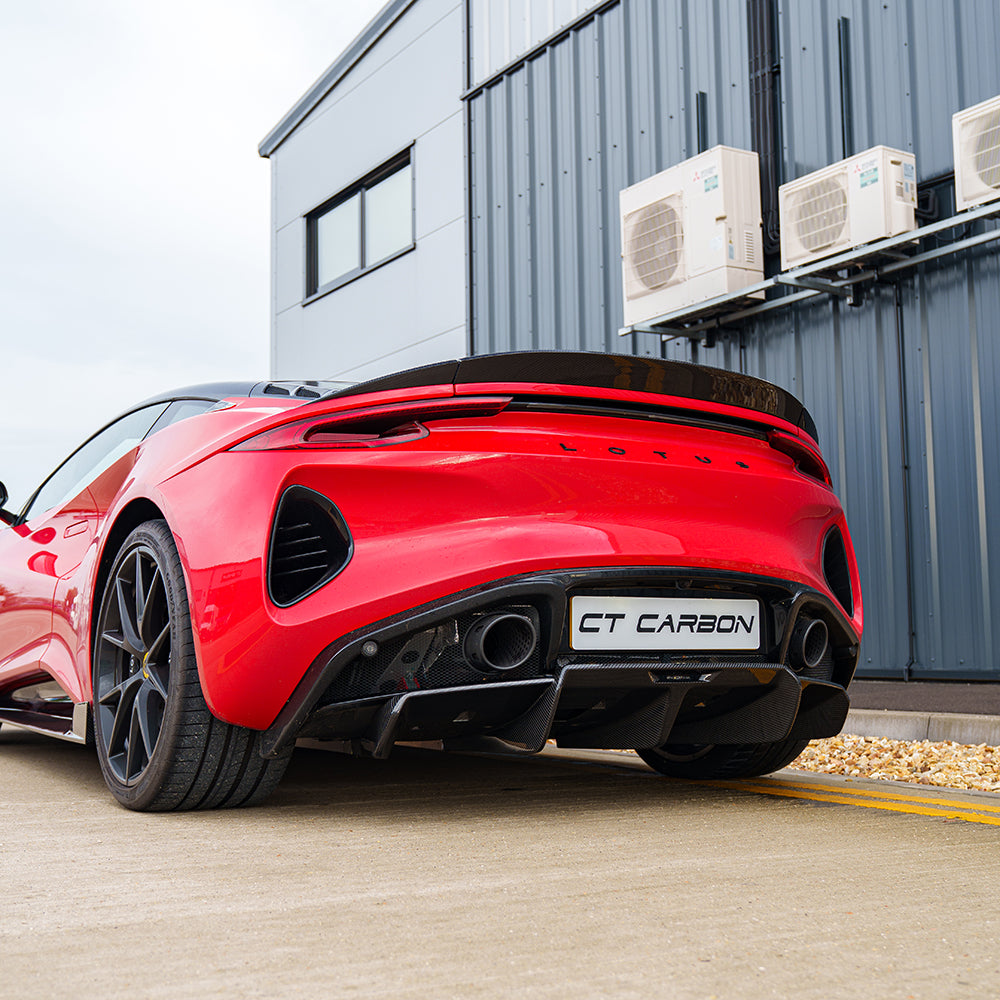 Red Lotus Emira car with CT Design carbon fiber rear diffuser, showcasing sleek aerodynamic styling and high-performance automotive design.
