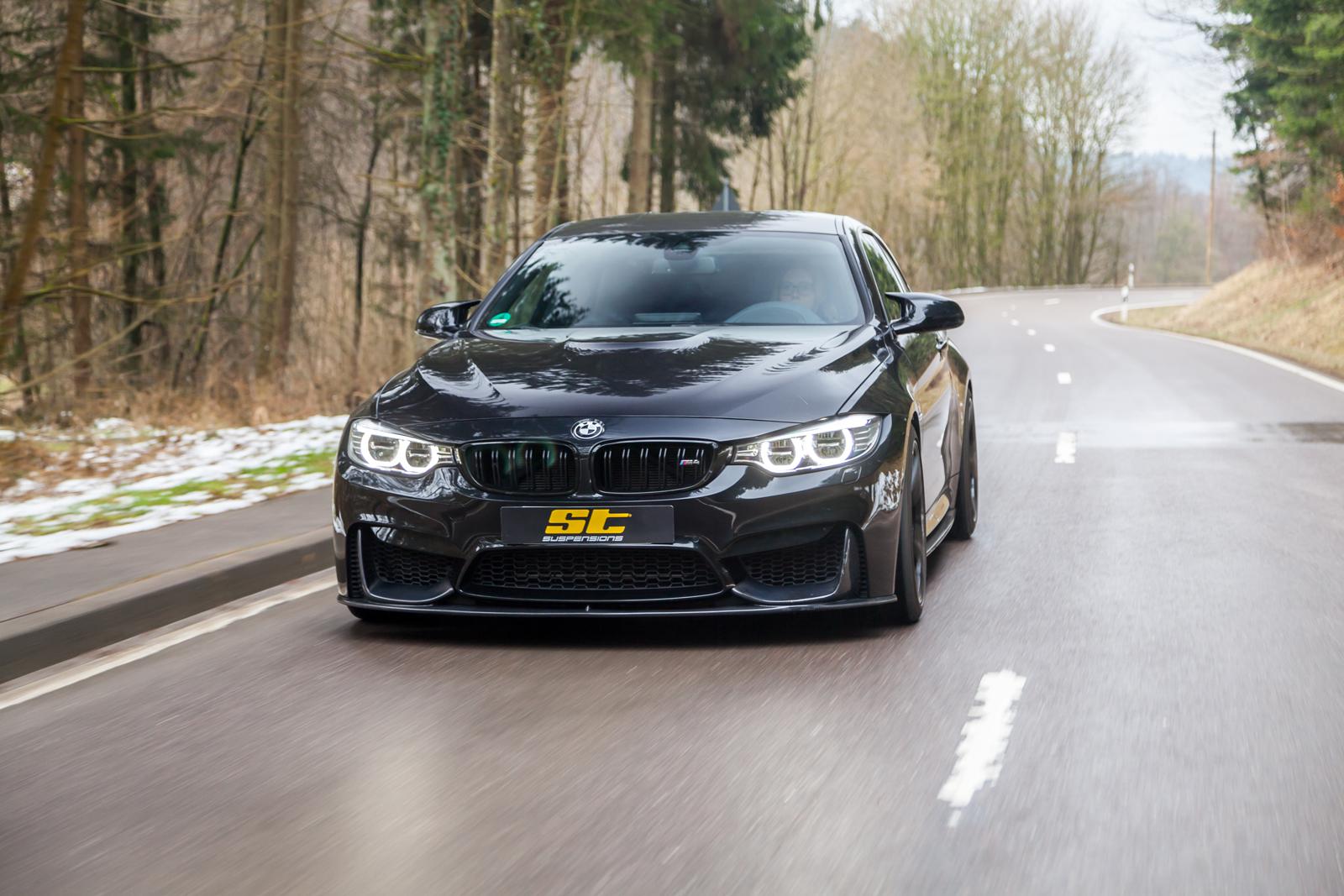 ST Suspension coilovers for BMW F80 M3 and F82 M4 coupe, featuring adjustable damping and top mounts, shown on a blue BMW M4.