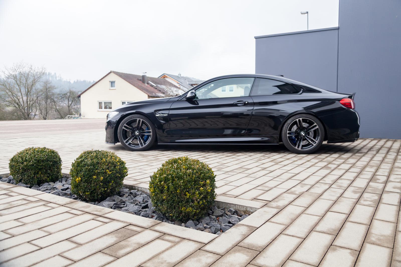 ST Suspension coilovers for BMW F80 M3 and F82 M4 coupe with adjustable damping and top mounts, shown installed on vehicle.
