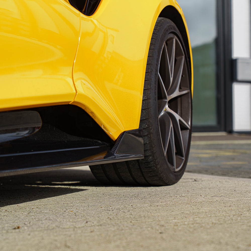 Yellow Lotus Emira with CT Carbon fiber side skirts, showcasing sleek, aerodynamic design and high-quality carbon fiber detailing.