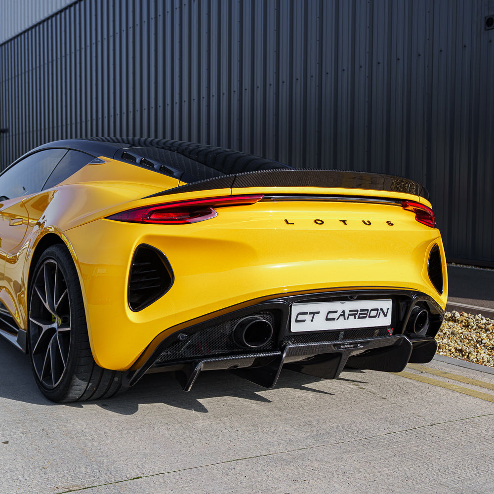 Yellow Lotus Emira car with CT Carbon fiber rear diffuser, showcasing sleek carbon fiber design and sporty rear styling.