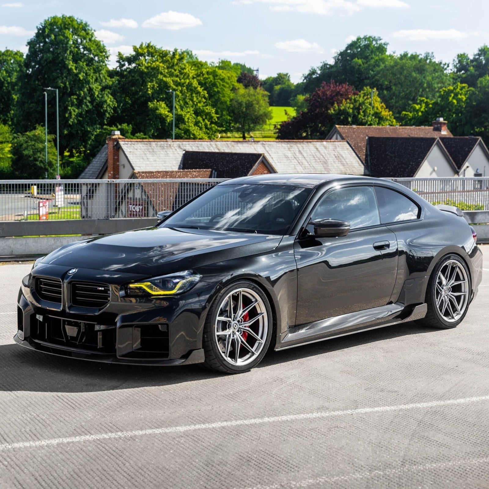 BMW G87 M2 TREVORA TR87 pre-preg carbon fibre side skirts, sleek aerodynamic design, installed on the car's sides.