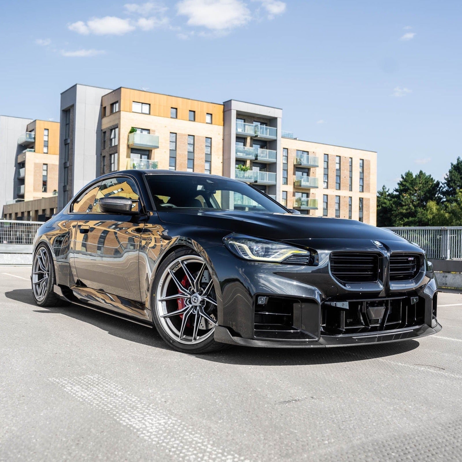 BMW G87 M2 TR87 Pre-preg Carbon Fibre Side Skirts by TREVORA installed on a vehicle, showcasing sleek, lightweight automotive styling.