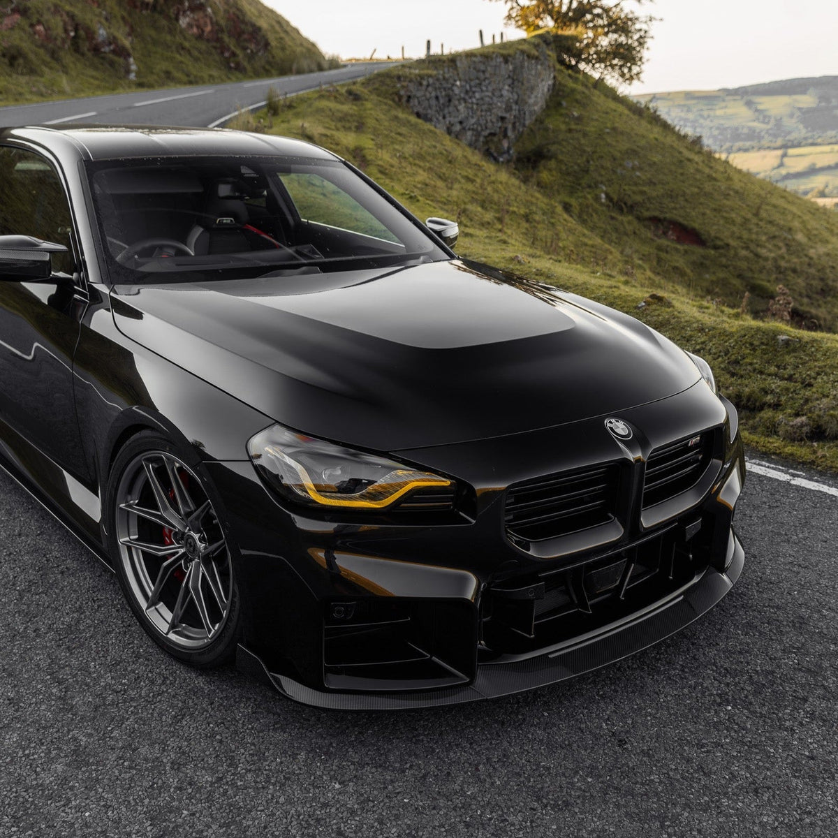 BMW G87 M2 TR87 front splitter with winglets in pre-preg carbon fibre by TREVORA, featuring aerodynamic design and detailed winglet accents.