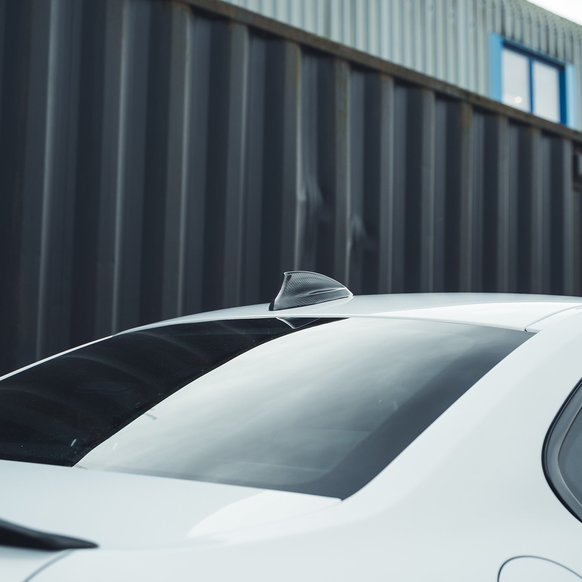 BMW Fxx carbon fibre antenna cover by CT Carbon, close-up view showing sleek black finish and detailed texture.